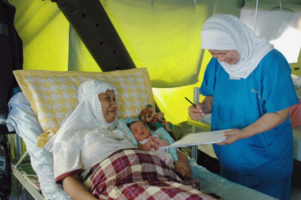 A tsunami survivor and her infant receive care following childbirth at Rumah Sakit Internasional (International Hospital), an emergency clinic in Long Raya, Aceh, Indonesia. Health remains a critical issue, especially for pregnant, post-partum and breastfeeding women.