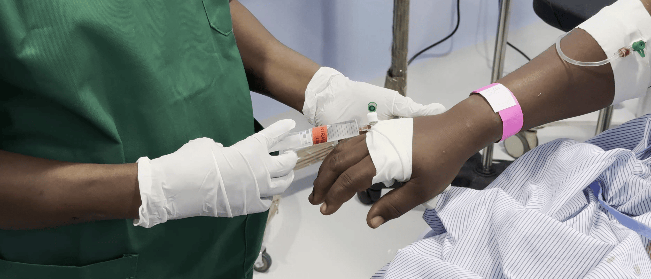 Healthcare worker administers tranexamic acid intravenously.